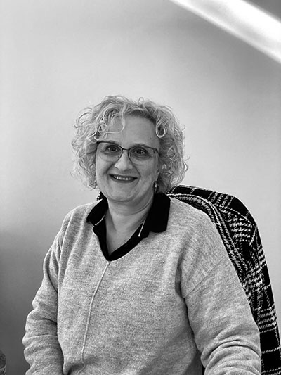 Mujer sonriente con gafas sentada en su oficina.